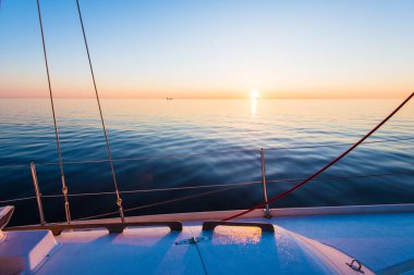 Gün batımında Baltık Denizi. Saf akşam ışığı ve suya yansıyan yansımalar. Yat manzaralı. Letonya