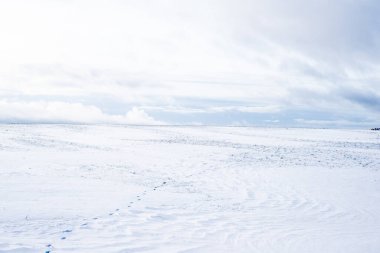 Gün batımında karla kaplı kırsal alanın panoramik manzarası. Akşam bulutları. Norveç