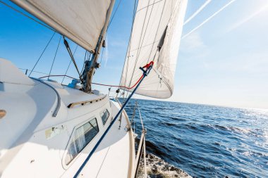 Açık bir Baltık Denizi 'nde güneşli bir günde beyaz yelkenli dolu bir yat. Güverteden pruvaya, direğe ve yelkenlere bir manzara. Estonya