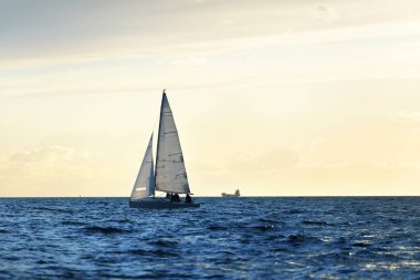 Gün batımında yelkenli tekneyle açılacak. Ilık akşam ışığı. Baltık Denizi, Letonya