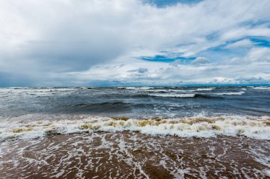 Dramatik gökyüzü ve dalgalar, deniz kıyısından bir manzara. Fırtınalı hava. Baltık Denizi, Letonya
