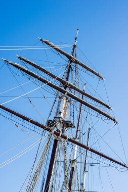 Açık bir yaz gününde rıhtımda yelkenli kullanmak. Geminin direği açık mavi gökyüzüne yakın mesafede. Rostock, Almanya