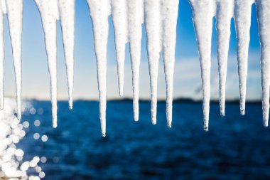 Güneşli bir günde, karla kaplı eski, paslı iskele. Buz parçaları yakın plan. Baltık Denizi, Letonya