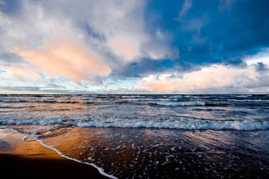 Renkli kış günbatımı. Soğuk fırtınalı dalgalar ve bulutlar Baltık Denizi üzerinde, Letonya