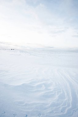 Gün batımında karla kaplı kırsal alanın panoramik manzarası. Akşam bulutları. Norveç