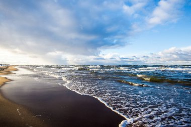 Renkli kış günbatımı. Soğuk fırtınalı dalgalar ve bulutlar Baltık Denizi üzerinde, Letonya