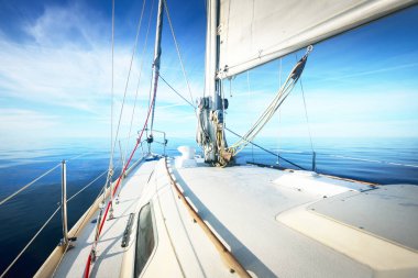 Açık bir Baltık Denizi 'nde güneşli bir günde beyaz yelkenli dolu bir yat. Güverteden pruvaya bir manzara. Estonya
