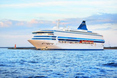 Baltık Denizi 'ndeki büyük beyaz yolcu gemisi. Renkli bir günbatımı gökyüzü. Letonya