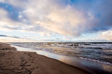 Renkli kış günbatımı. Soğuk fırtınalı dalgalar ve bulutlar Baltık Denizi üzerinde, Letonya