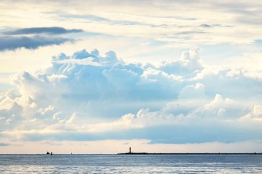 Baltık Denizi 'nin üzerindeki muhteşem gökyüzü. Arka planda deniz feneri var. Yaz batımı. Letonya