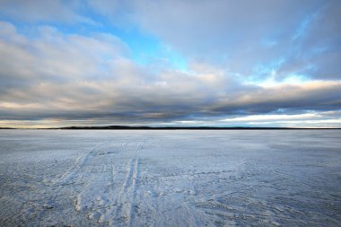 Gün batımında donmuş Onega Gölü manzarası. Renkli bulutlu dramatik akşam gökyüzü. Şaşırtıcı bulut manzarası. Karelia, Rusya