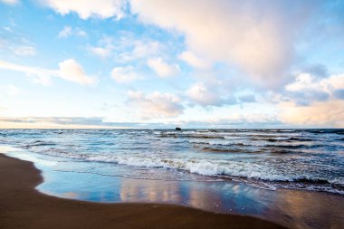 Renkli kış günbatımı. Soğuk fırtınalı dalgalar ve bulutlar Baltık Denizi üzerinde, Letonya