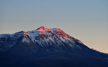 Güneşli bir kış gününde dağ zirveleri. Açık mavi gün batımı gökyüzü, altın ışık, pembe renk. Fransız Alpleri, Ecrins Massif, Fransa. Idyllic manzara. Doğa, mevsimler, kış, kayak, Noel tatilleri