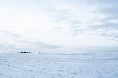 Gün batımında karla kaplı kırsal alanın panoramik manzarası. Akşam bulutları. Norveç