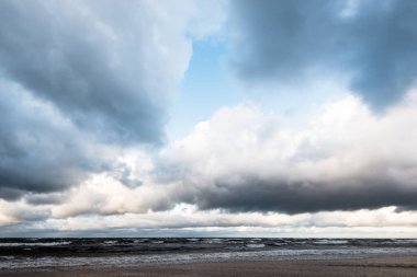 Sonbahar. Denizin üstünde fırtına bulutları. Dalgalar ve su sıçramaları. Sıcak akşam güneşi. Baltık Denizi, Garciems, Letonya