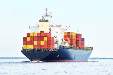 Norfolk limanından ayrılan büyük bir yük konteynırı gemisi, yakın plan. Bulutlu mavi gökyüzü. Virginia, ABD