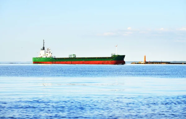 晴れた日にバルト海を航海する大型貨物船 背景に灯台 ラトビア — ストック写真