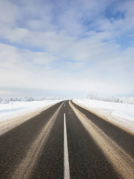 一个空旷蜿蜒的S形高速公路穿过雪地 村庄的景象 冬季乡村风景 圣诞假期 危险驾驶 越野旅行 — 图库照片