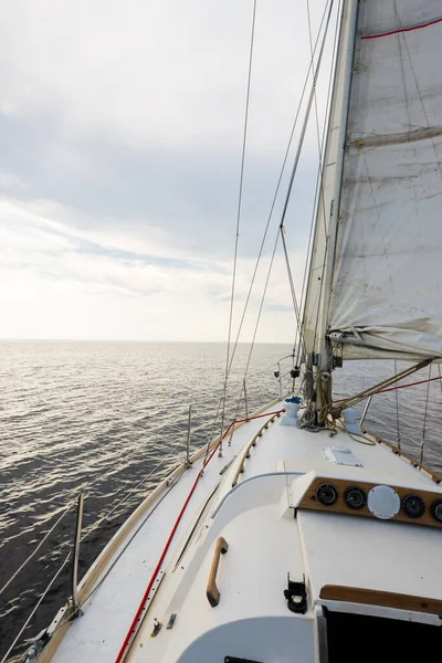ホワイト スループはアメリカ南西部のメイン州の海岸近くを航行するヨットを操縦した デッキから弓 マスト 帆への眺め 暗い青い嵐の空 雲の中の太陽光線 — ストック写真