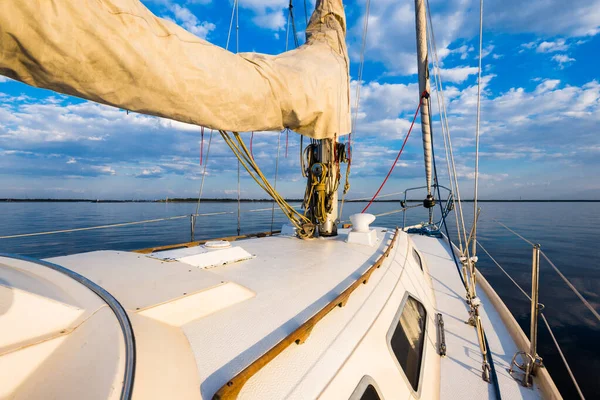 白いヨットは日没時に静かな水の中を航海する デッキから弓 マスト 帆への眺め 見事な雲景だ 自然鏡だ スポーツとレクリエーションのテーマ バルト海 ラトビア — ストック写真