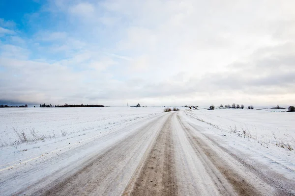 日没時に雪に覆われた田園地帯を通る道路 晴れた冬の日 — ストック写真