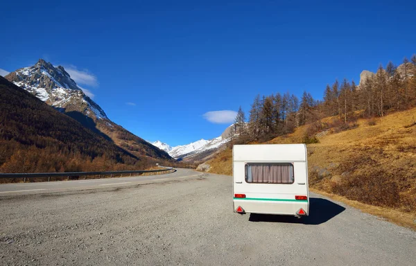 Caravan trailer stucked near the border of Italy because of travel ban, close-up. Coronavirus (COVID-19) outbreak, quarantine zone in France. An empty highway in a French Alps mountains on a clear day