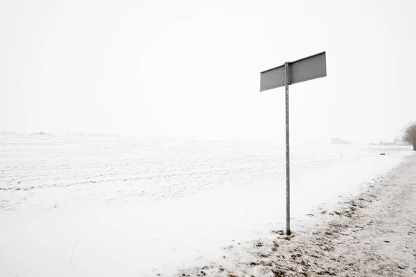 Tom Landsväg Genom Snötäckta Fälten Mulen Vinterdag Vägskylt Närbild Lettland — Stockfoto