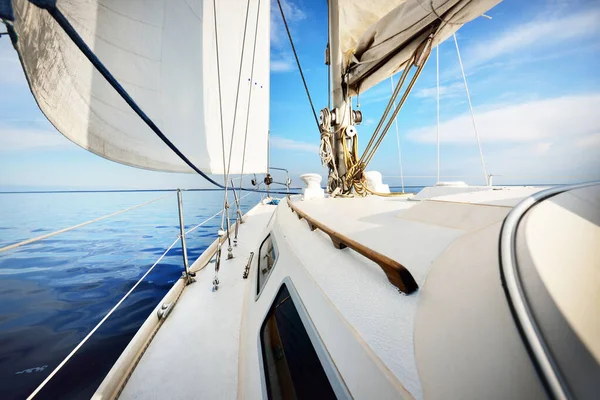 美国西南港缅因州海岸附近的一艘白色小船上了帆 从甲板到船头的景色 桅杆和帆 深蓝色的暴风雨天空 阳光穿过云彩 — 图库照片