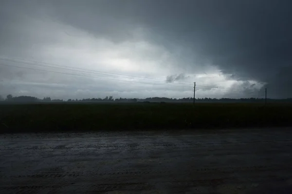 雷雨の中の空の未舗装の道路 農地の上に劇的な空 夏の風景 ラトビア — ストック写真