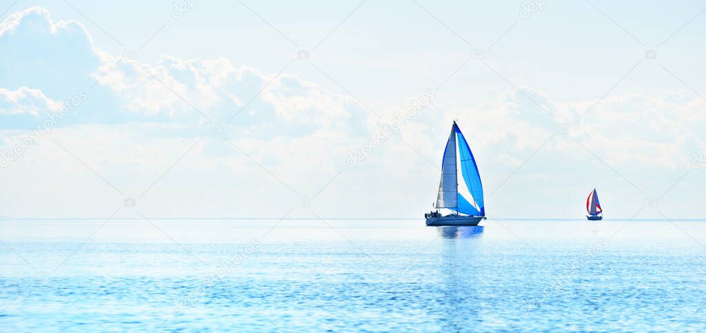 Sailing yacht regatta. Modern sailboats racing with blue spinnaker sails. Clear summer day. Kiel, Germany