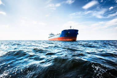 Bulutlu mavi gökyüzünün altında kargo gemisi, Baltık denizi, Letonya