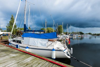 Yelkenli bir rıhtıma demirlemiş, yakın plan. Bulutlu bir yaz gününde yat kulübünün manzarası. Riga Limanı, Letonya