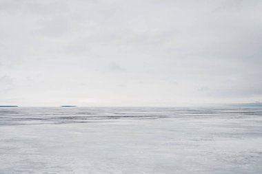Kış manzarası. Donmuş karla kaplı göl manzarası. Arka planda orman var. Fırtınalı akşam bulutları. Onega Gölü, Karelia, Rusya
