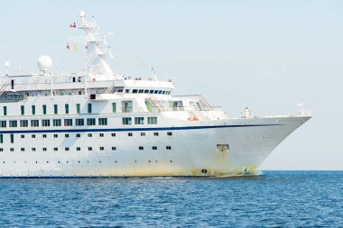 Baltık Denizi 'nde büyük beyaz yolcu gemisi, yakın plan. Arka planda deniz feneri var. Riga Körfezi, Letonya