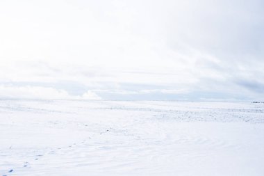 Gün batımında karla kaplı kırsal alanın panoramik manzarası. Akşam bulutları. Norveç