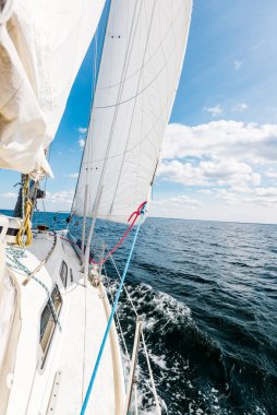 Güneşli bir günde beyaz bir yat denize açılıyor. Güverteden pruvaya, direğe ve yelkenlere bir manzara. Norveç