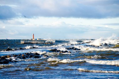 Fırtınalı mavi gökyüzüne karşı deniz feneri. Baltık Denizi, Letonya