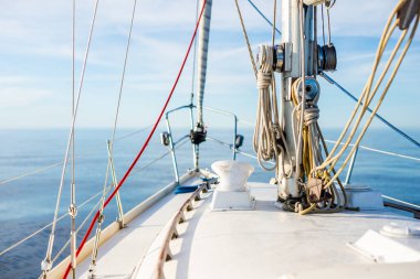 Açık bir Baltık Denizi 'nde güneşli bir günde beyaz yelkenli dolu bir yat. Güverteden pruvaya bir manzara. Estonya