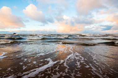 Renkli kış günbatımı. Soğuk fırtınalı dalgalar ve bulutlar Baltık Denizi üzerinde, Letonya