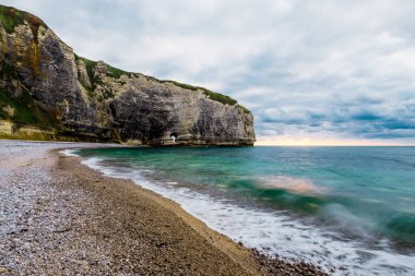 Gün batımında Etretat beyaz kayalıklarının manzarası. Açık mavi gökyüzü. Normandiya, Fransa