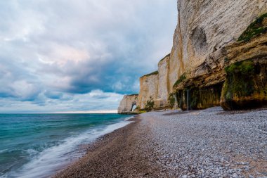 Gün batımında Etretat beyaz kayalıklarının manzarası. Açık mavi gökyüzü. Normandiya, Fransa