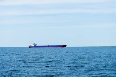 Açık bir günde açık bir Baltık Denizi 'nde yelken açan büyük mavi kargo gemisi. Letonya