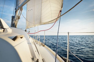 Açık bir Baltık Denizi 'nde açık bir günde yelkenli dolu bir yat. Güverteden pruvaya, direğe ve yelkenlere yakın görüntü. Letonya