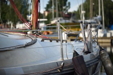 Açık bir yaz gününde, yakın planda beyaz bir yat iskeleye demirlemiş. Riga Limanı, Letonya