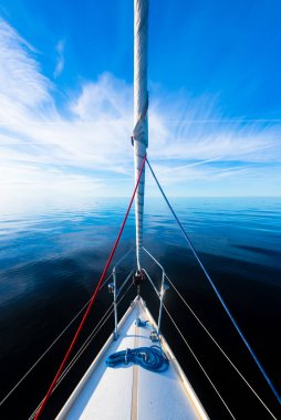 Açık bir Baltık Denizi 'nde güneşli bir günde beyaz yelkenli dolu bir yat. Güverteden pruvaya bir manzara. Estonya