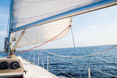 Açık bir Baltık Denizi 'nde açık bir günde yelkenli dolu bir yat. Güverteden pruvaya, direğe ve yelkenlere yakın görüntü. Letonya