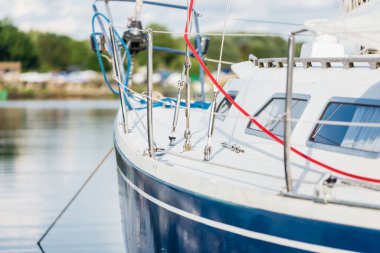 Açık bir yaz gününde, yakın planda mavi bir yat iskeleye demirlemiş. Riga Limanı, Daugava Nehri, Letonya