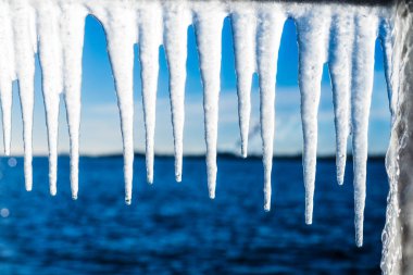Güneşli bir günde, karla kaplı eski, paslı iskele. Buz parçaları yakın plan. Baltık Denizi, Letonya