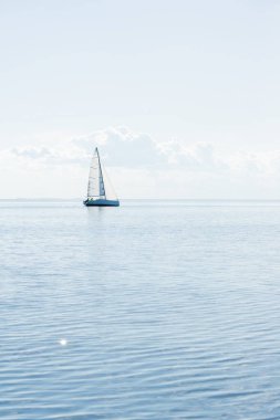 Akdeniz 'de güneşli bir günde, İspanya' da beyaz yelkenli donanımlı, modern bir yat gezintisi. Beyaz bulutlu mavi gökyüzü, suda yansımalar.;