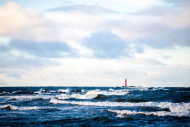 Fırtınalı mavi gökyüzüne karşı deniz feneri. Baltık Denizi, Letonya